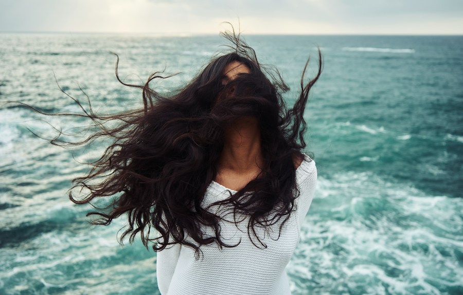 Woman with long dark wavy hair blowing in the wind