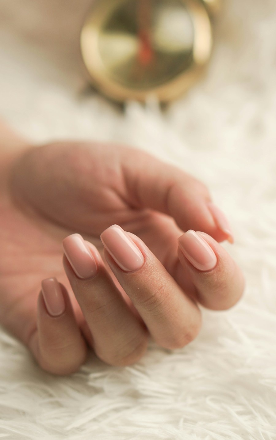 Hand with soft nude manicured nails